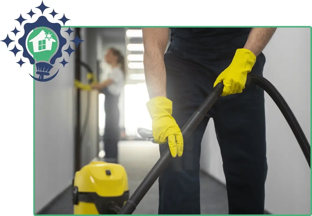Professional cleaning service worker vacuuming the floor with yellow gloves, with another cleaner in the background.