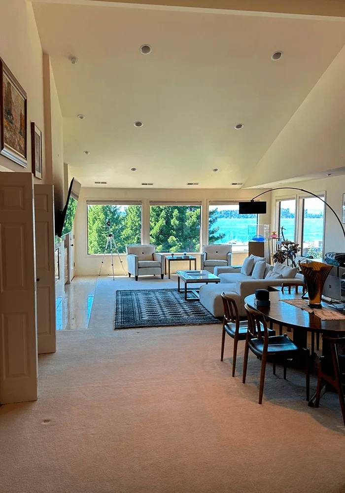 A large, open-plan living and dining room with professionally cleaned carpets and a beautiful view, ready for move-in.