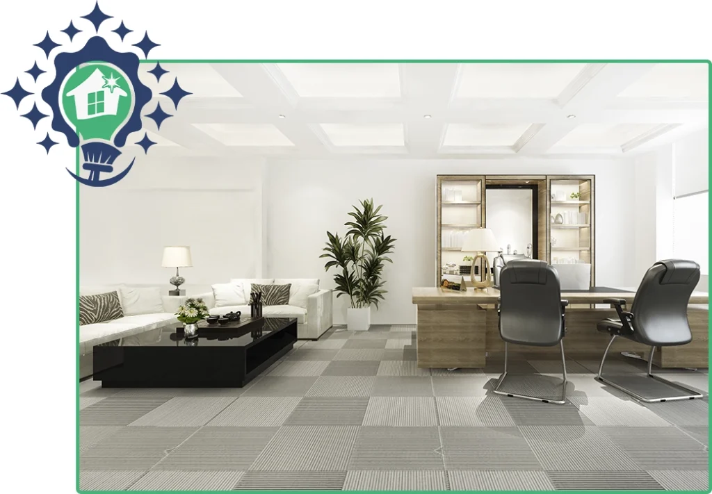 Spacious and clean modern office interior with a white sofa, wooden desk, and patterned carpet tiles, ideal for a professional environment.