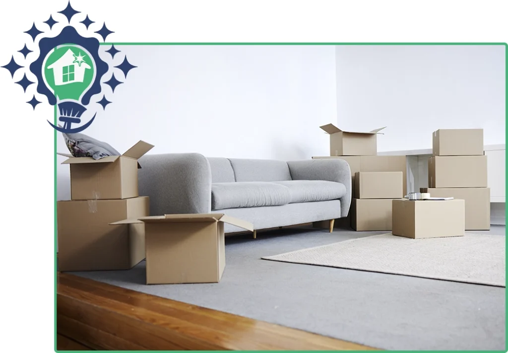 Living room with a gray sofa surrounded by open and sealed cardboard moving boxes, ready for packing or unpacking.