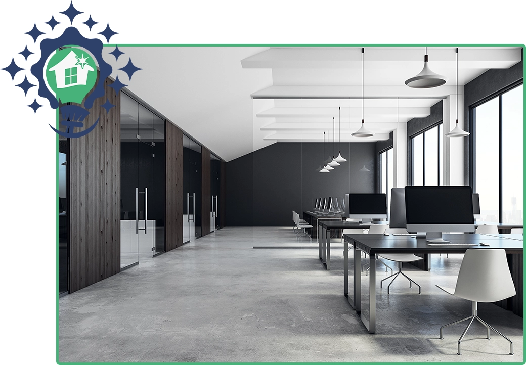 Clean and modern open-plan office space with multiple computer workstations, large windows, and a professional cleaning service logo.